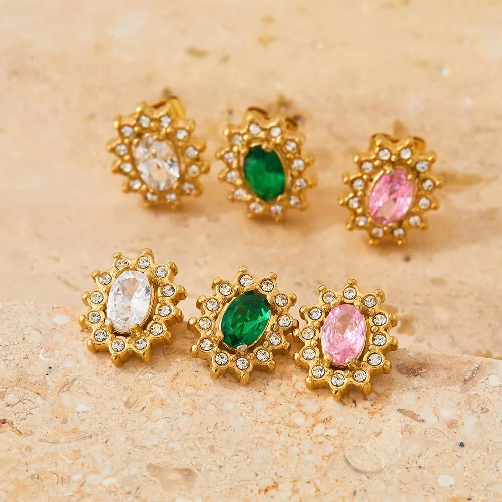 Gold zircon jewelry assortment on a neutral stone surface